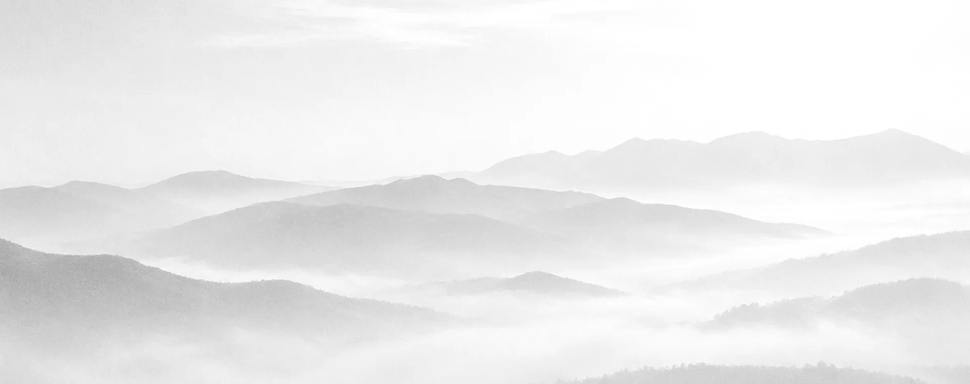 Cadenas de montañas entre niebla clara, en blanco y negro