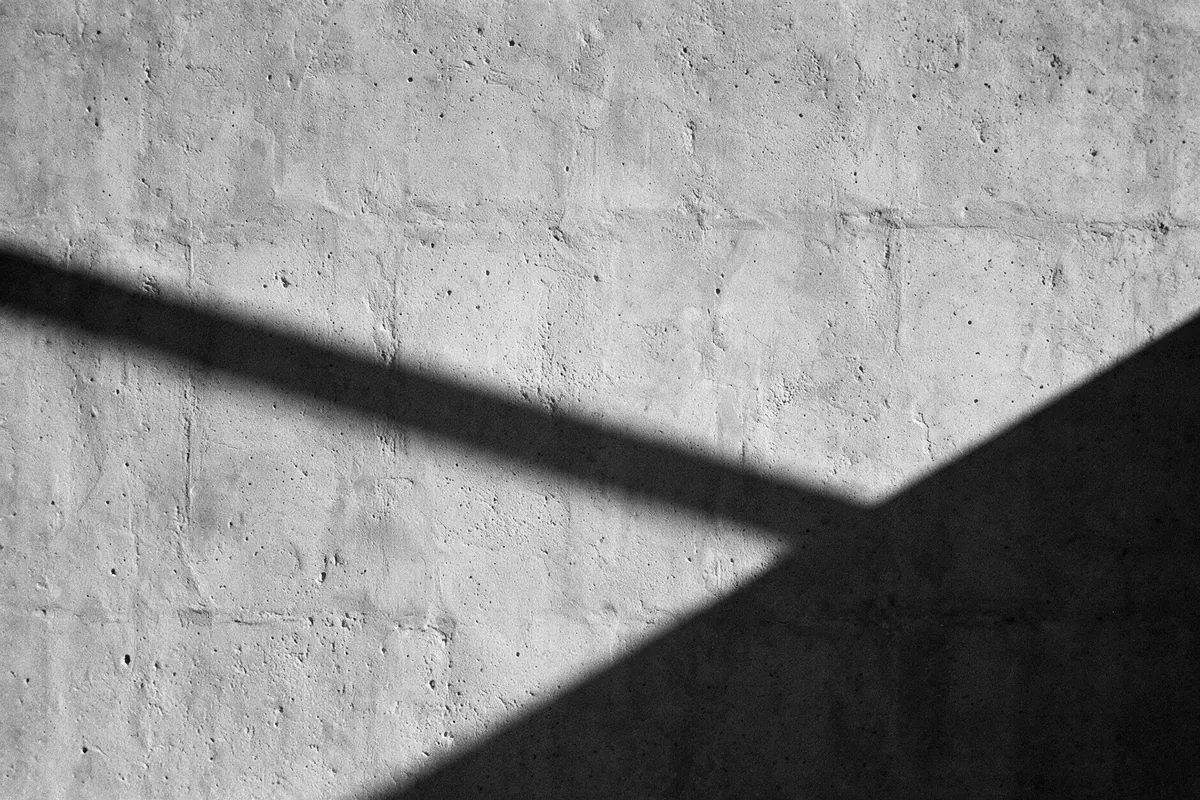 Textura de concreto en blanco y negro con una sombra diagonal marcada