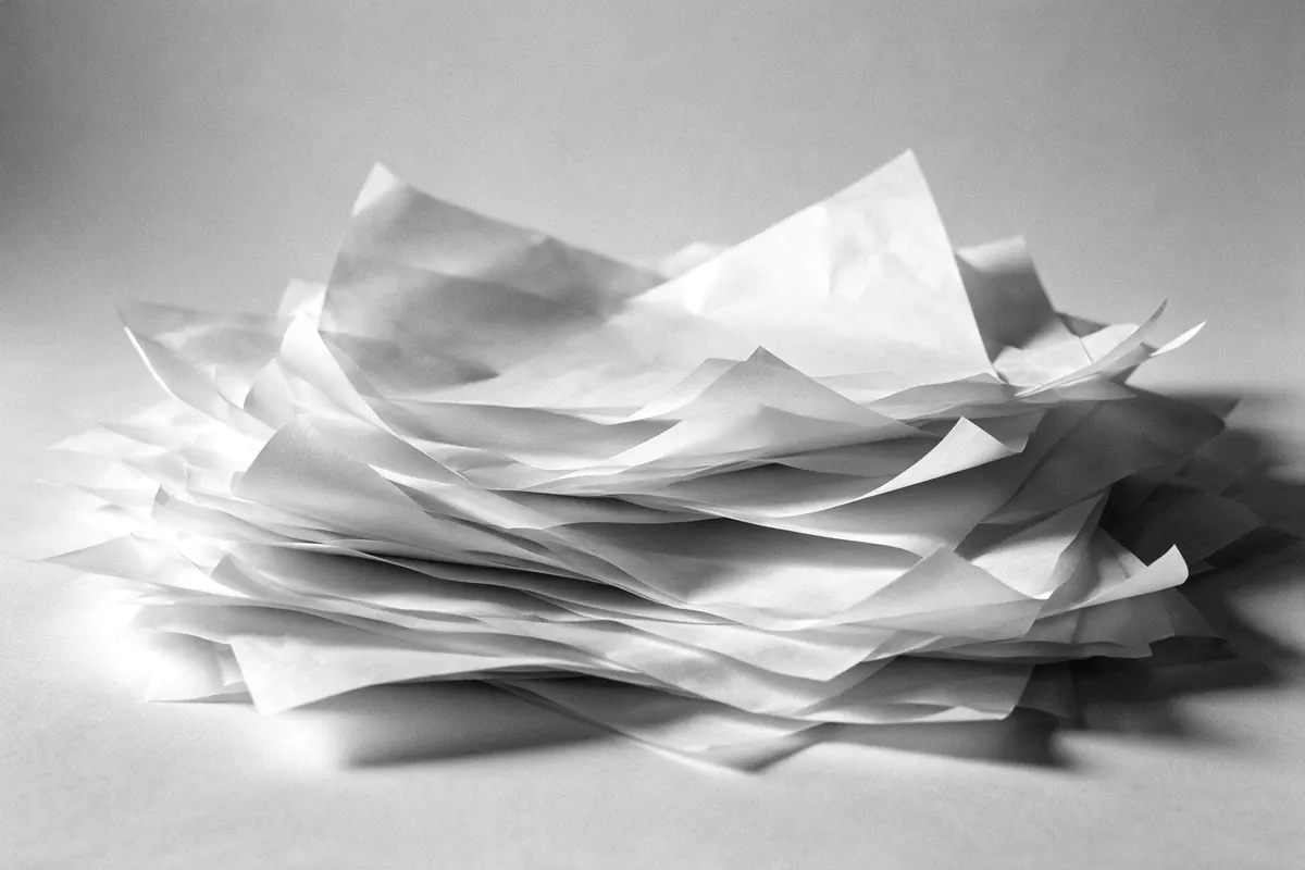 Hojas de papel plegadas en blanco y negro con sombras superpuestas
