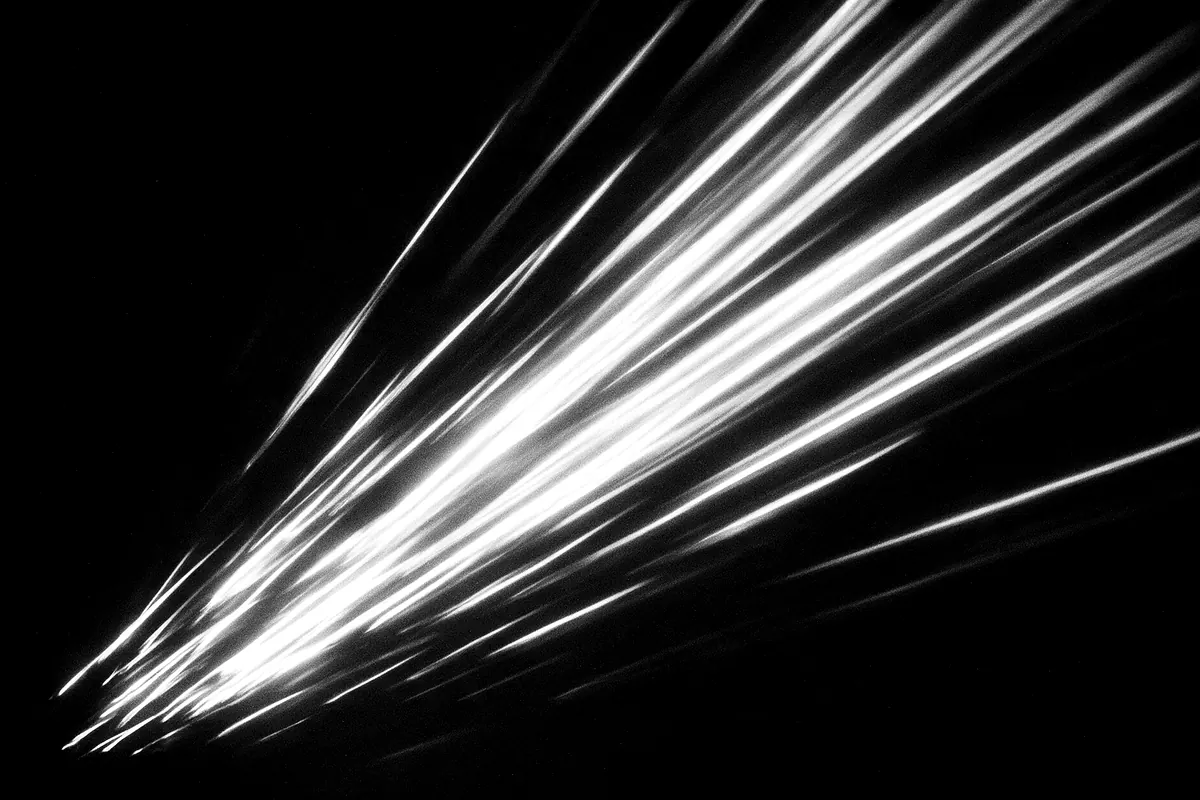 Estelas de luz en blanco y negro formando trazos diagonales de movimiento