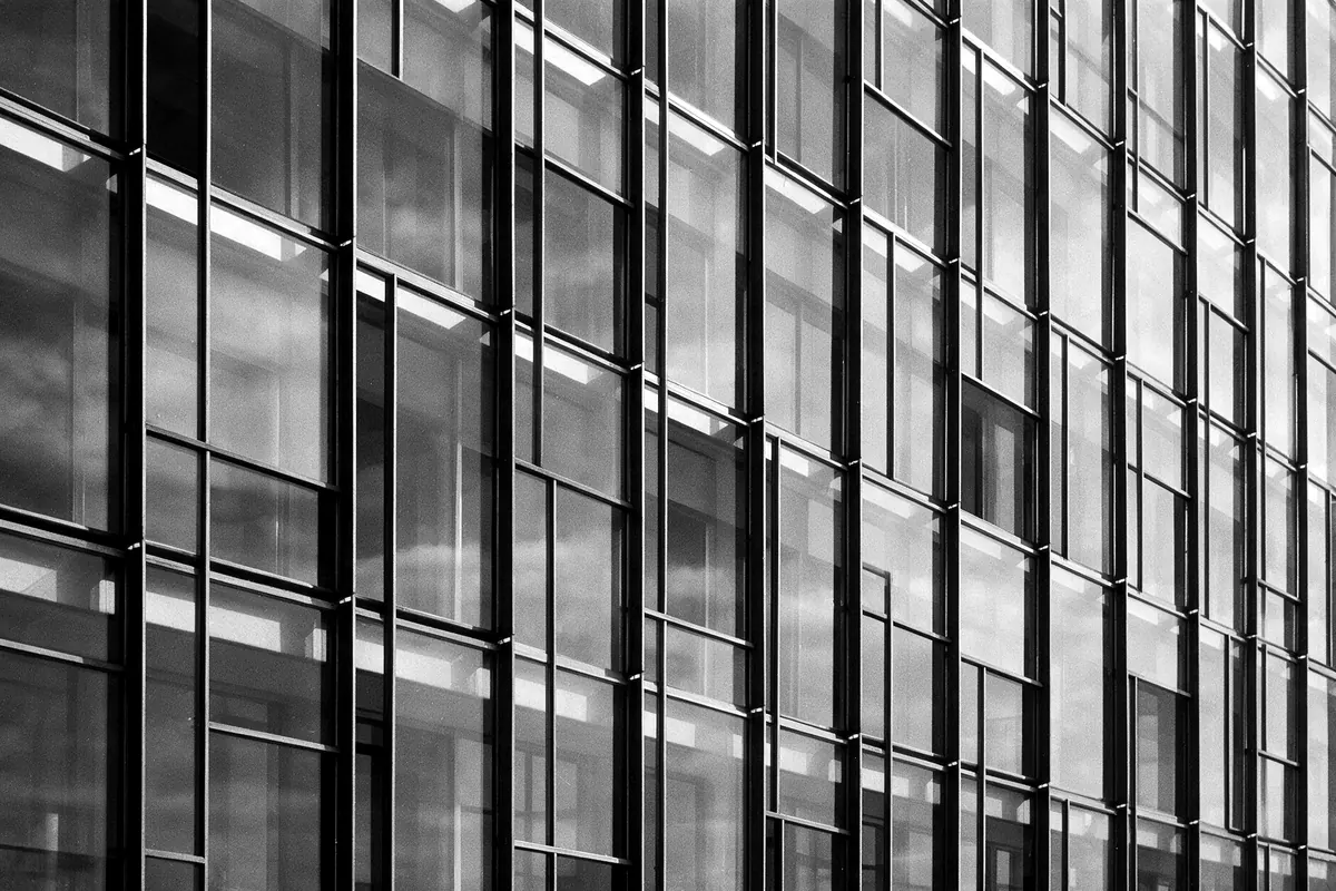 Fachada modernista de vidrio y acero en blanco y negro con retícula repetida